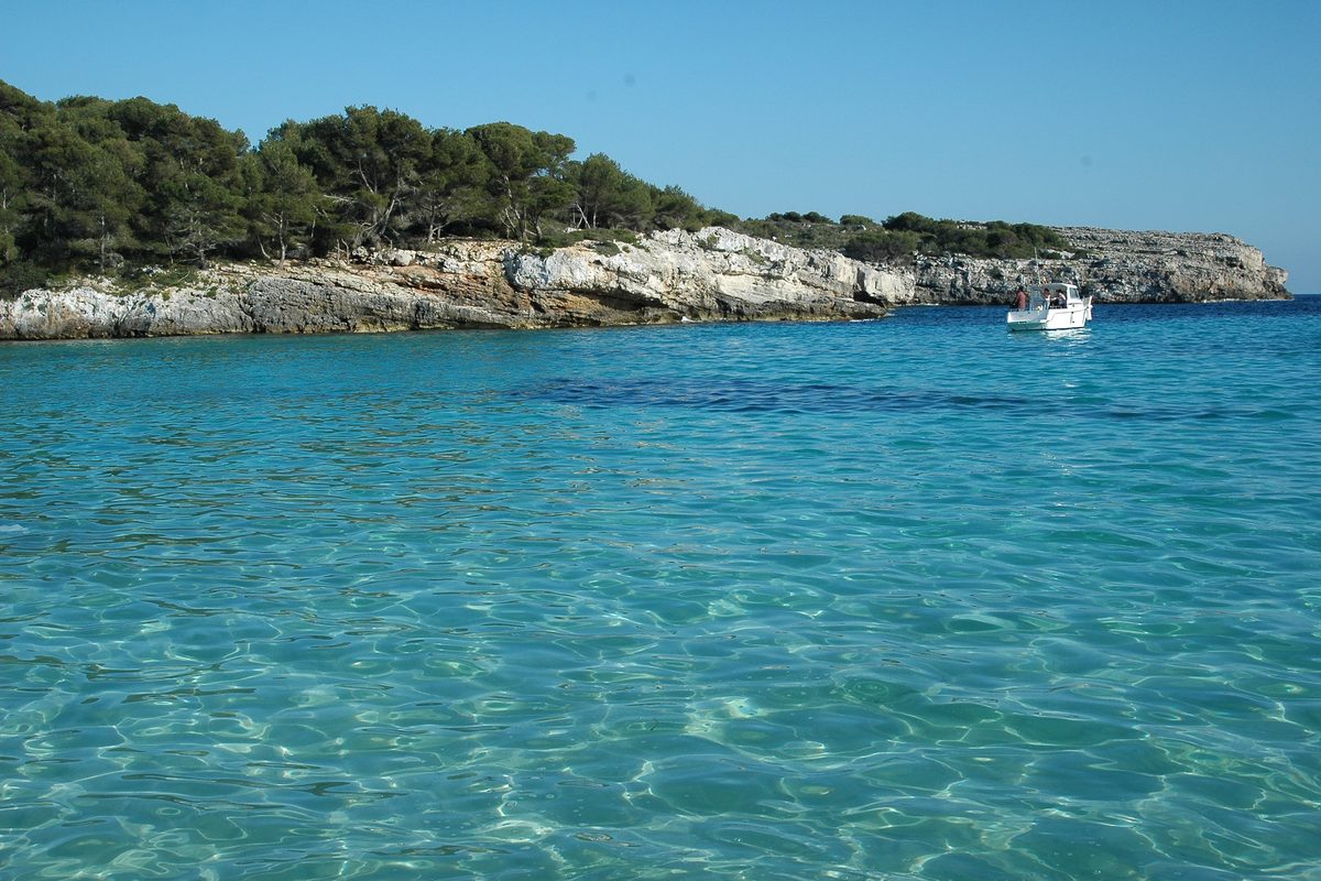 Una embarcación fondeada frente a Cala en Turqueta
