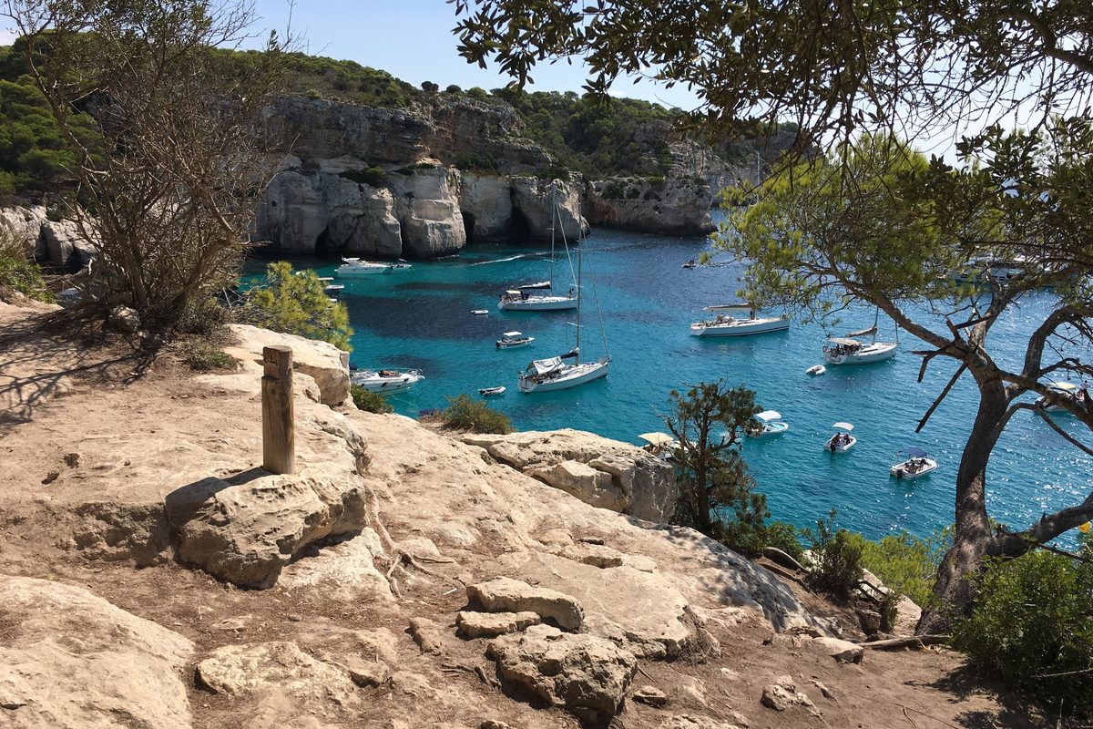 El Camí de Cavalls asomado a Cala Macarella, con barcos fondeados