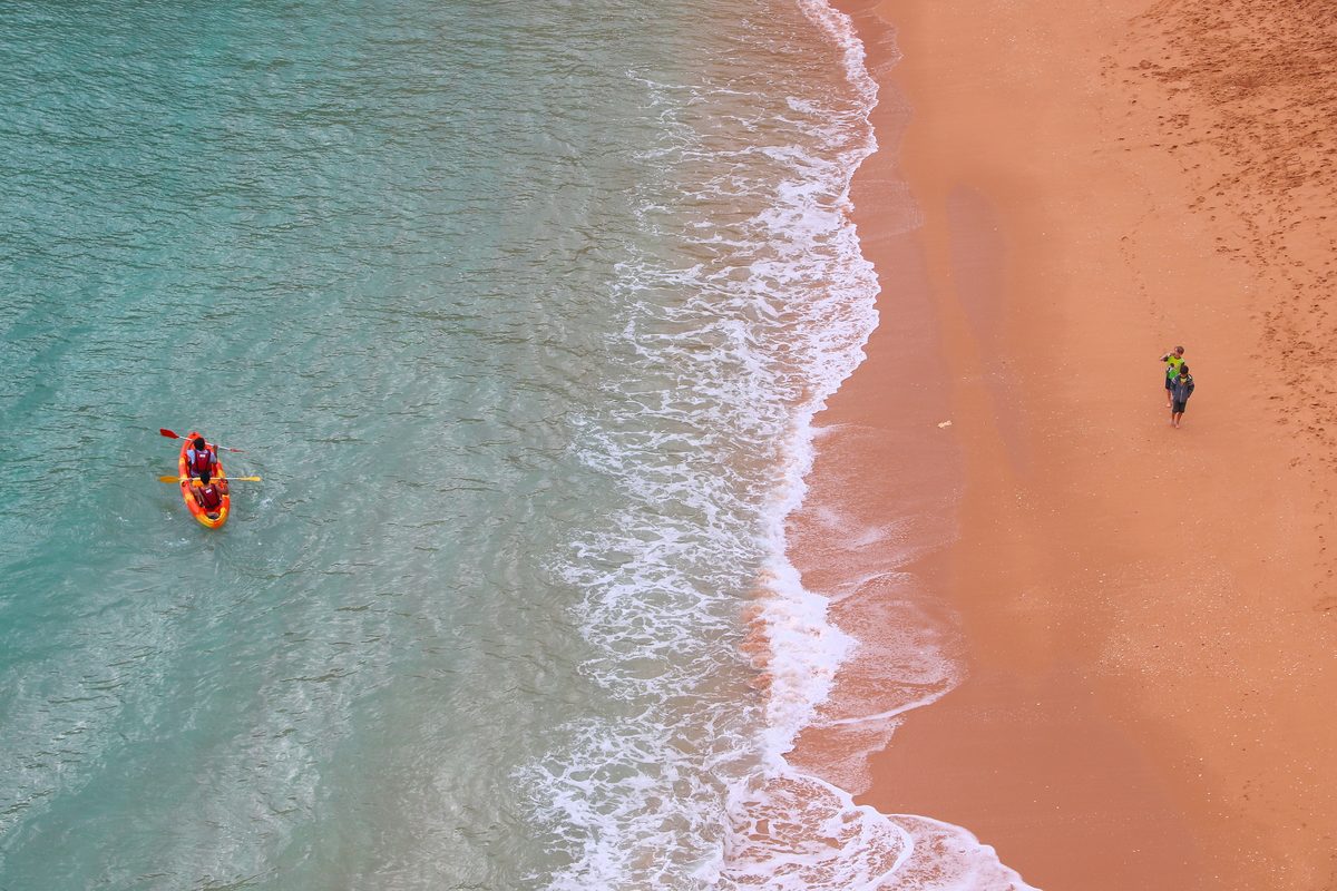 Kayak navegando sobre aguas turquesas junto a la playa